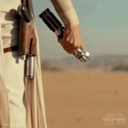 a person is holding a light saber in their hand .