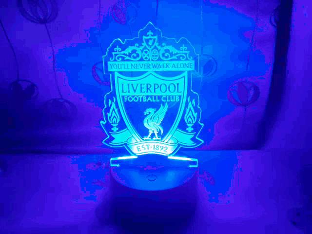 a liverpool football club emblem is lit up in blue light
