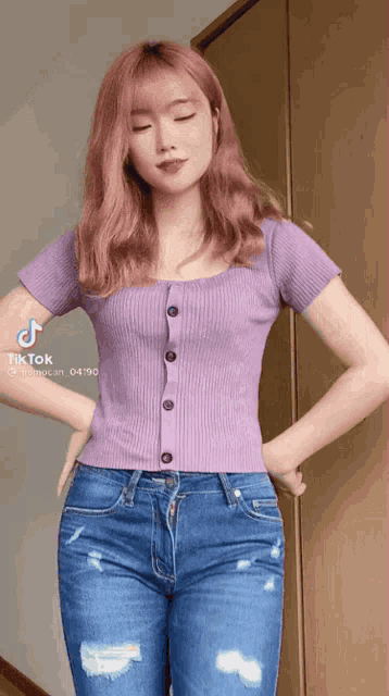 a girl with pink hair is wearing a purple shirt