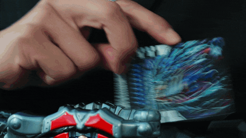 a close up of a person 's hand holding a toy