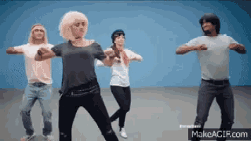 a group of people are dancing in front of a blue background and the website makeagif.com is visible