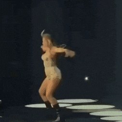 a woman is dancing on a stage with a microphone .