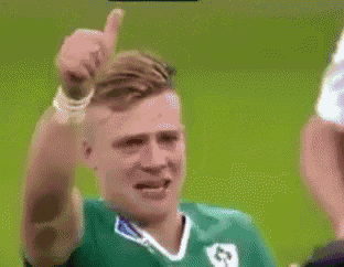 a man in a green jersey with the number 63 on it is giving a thumbs up
