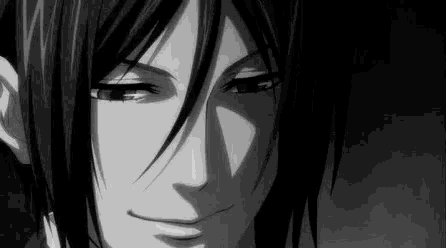 a black and white photo of a man with long black hair smiling .