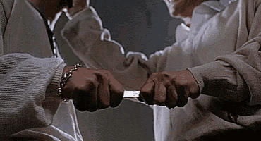 a man is holding a knife in his hand and another man is holding a knife in his hand .