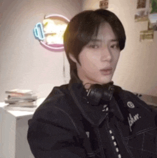 a young man wearing headphones is sitting in a chair in a room .