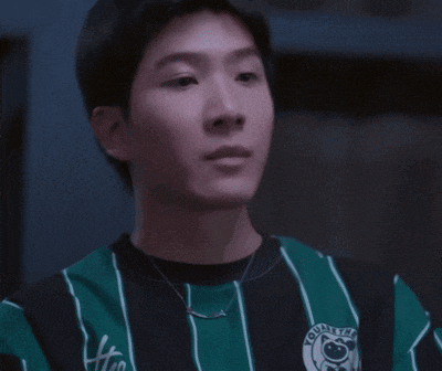 a young man wearing a green and black striped shirt with the word united on it