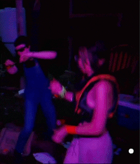 two people are standing in a dark room and one of them is wearing a vest that says ' r.i.t. '