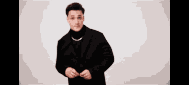 a man in a black coat is pointing his finger