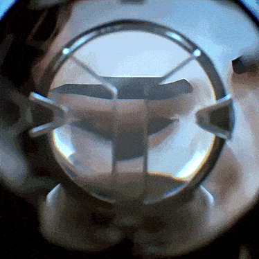 a close up of a circular object with a reflection of a person 's face in it