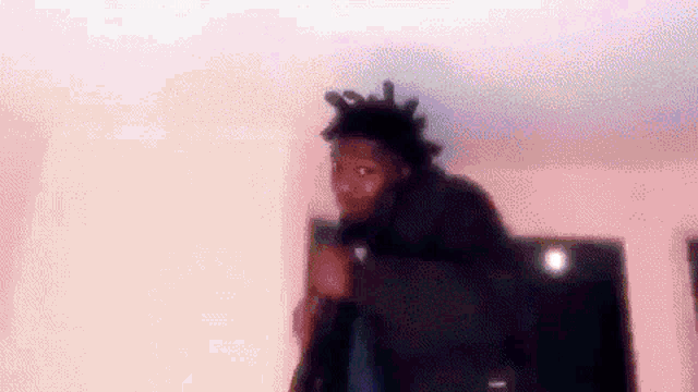 a blurry picture of a man standing in a room with a microphone in his hand .