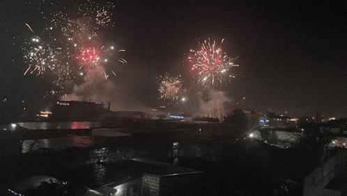 fireworks are displayed over a city at night with a sign that says ' a ' on it