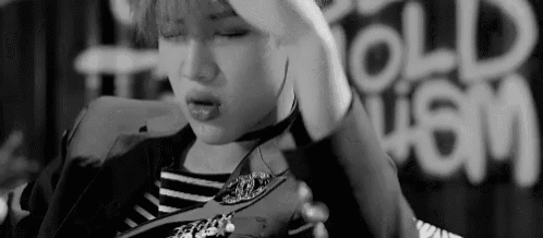 a black and white photo of a person holding their hand to their head .