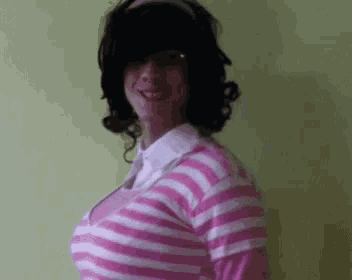 a woman is wearing a pink and white striped shirt and a headband .