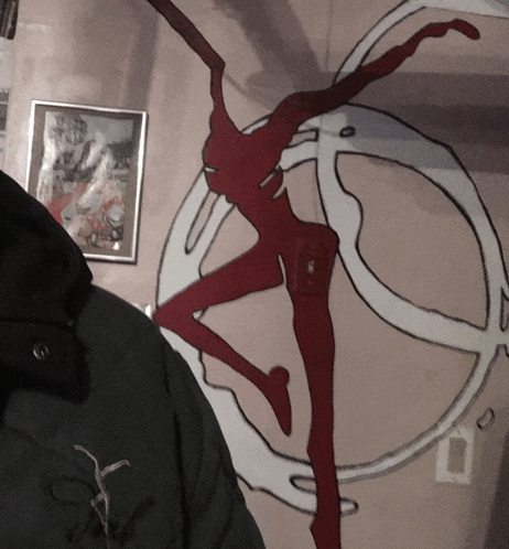 a person standing in front of a peace sign with a red figure in the middle