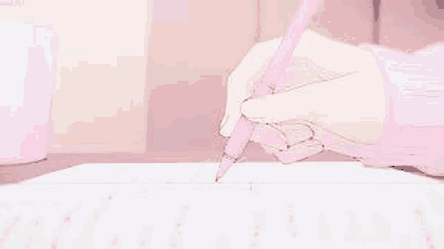 a person is writing on a piece of paper with a pencil .