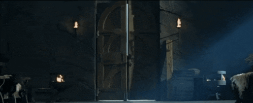 a man is walking through an open door in a dark room