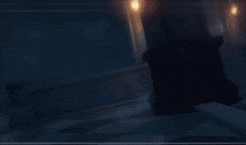 a woman wearing a hat and gloves is standing in a dark room .