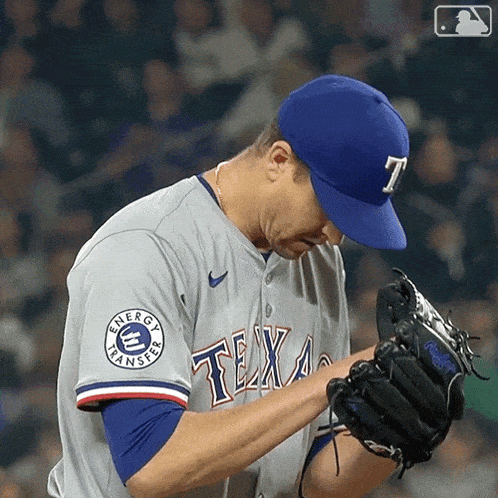 a baseball player wearing a texas jersey looks down