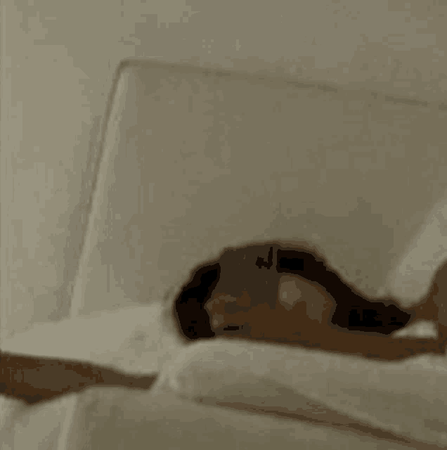 a woman is laying in bed holding a cell phone .