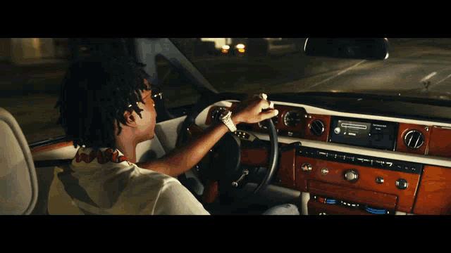 a man is driving a car with a radio that says ' spotify ' on it