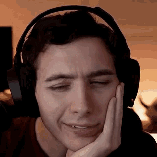 a man wearing headphones is making a sad face