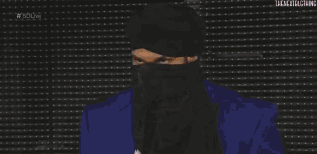 a man with a beard is wearing a blue jacket and a black hat