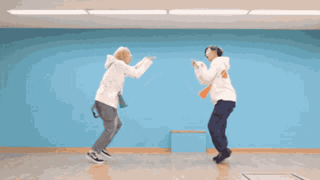 two people are dancing in a room with blue walls