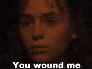 a close up of a woman 's face with the words " you wound me " below her
