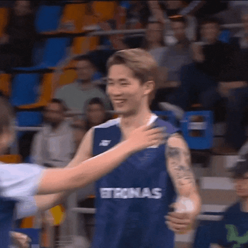 a basketball player wearing a technas jersey is hugged by another player