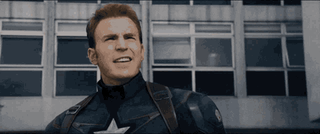 a close up of captain america 's face with a building in the background