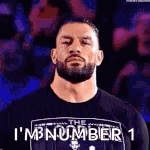 roman reigns is wearing a black t-shirt with the words `` i 'm number 1 '' on it .