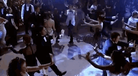 a large group of people are dancing together on a dance floor .