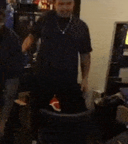 a man in a black shirt is standing in front of a computer monitor .