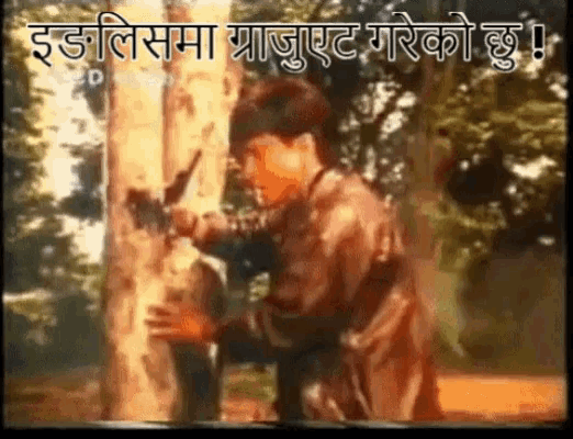 a man is standing next to a tree holding a gun in a video in a language other than english .