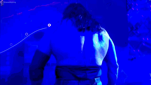 a person is standing in front of a blue and purple light