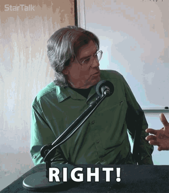 a man in a green shirt stands in front of a microphone with the word right on the table