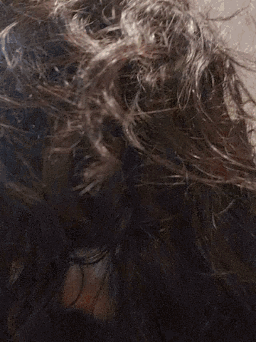a close up of a person 's hair blowing in the wind