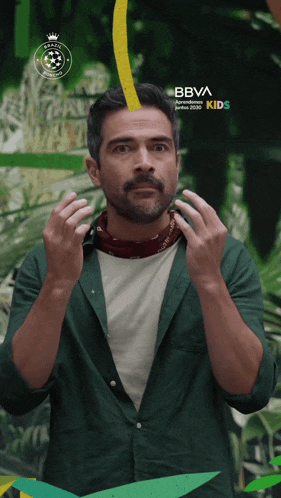 a man in a green shirt stands in front of a sign that says bbva kids