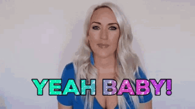 a woman in a blue shirt is smiling and saying yeah baby !