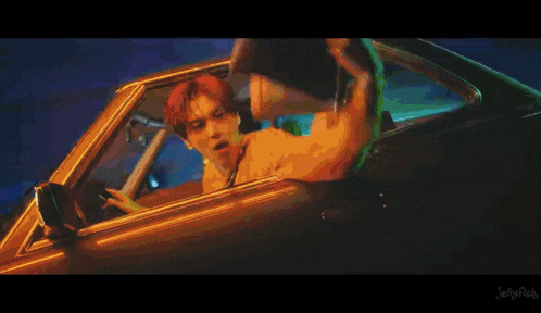 a man leans out of the window of a car with jellyfish written on the bottom