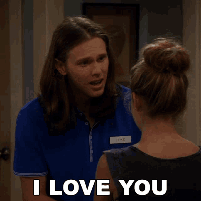 a man with a name tag that says luke stands next to a woman who says i love you