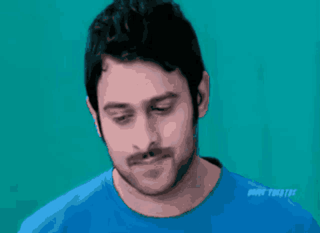 a man with a mustache is wearing a blue shirt that says www.tnc31m