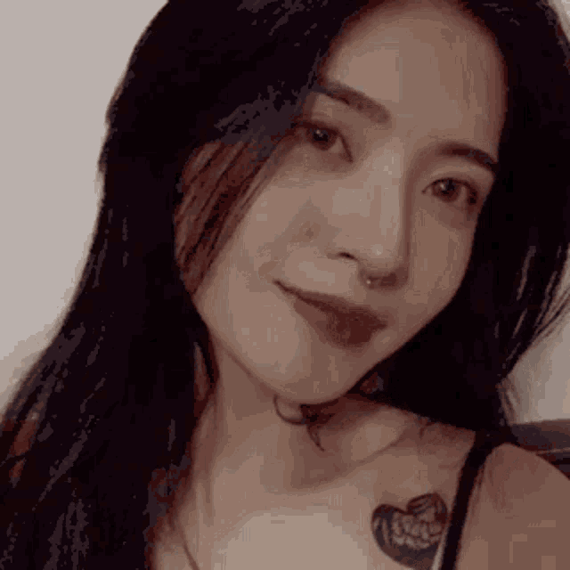 a close up of a woman 's face with a butterfly tattoo on her chest