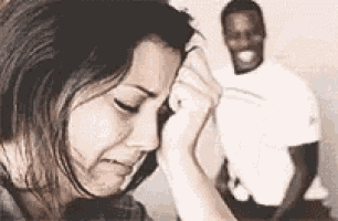 a woman is crying in front of a man who is smiling .