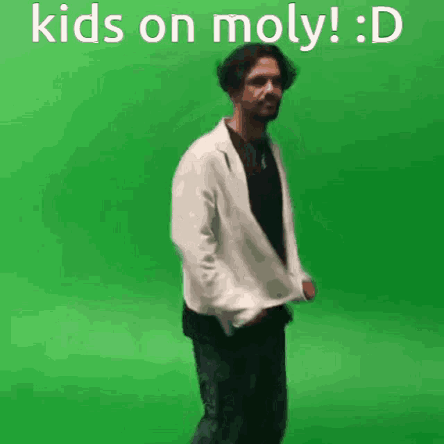 a man in a white jacket is dancing in front of a green screen with the words kids on moly : d written on it .