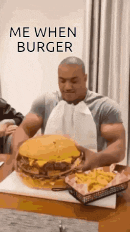 a man is sitting at a table eating a very large hamburger .