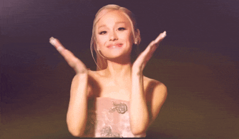 a woman in a pink dress is clapping her hands in the air