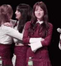 a woman in a red dress is hugging another woman in a white shirt .