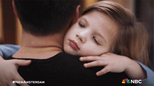 a little girl hugging a man with the nbc logo on the bottom right